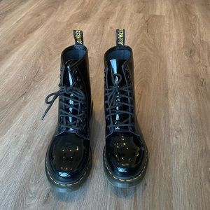 Dr. Martens lace up black patent leather boots.